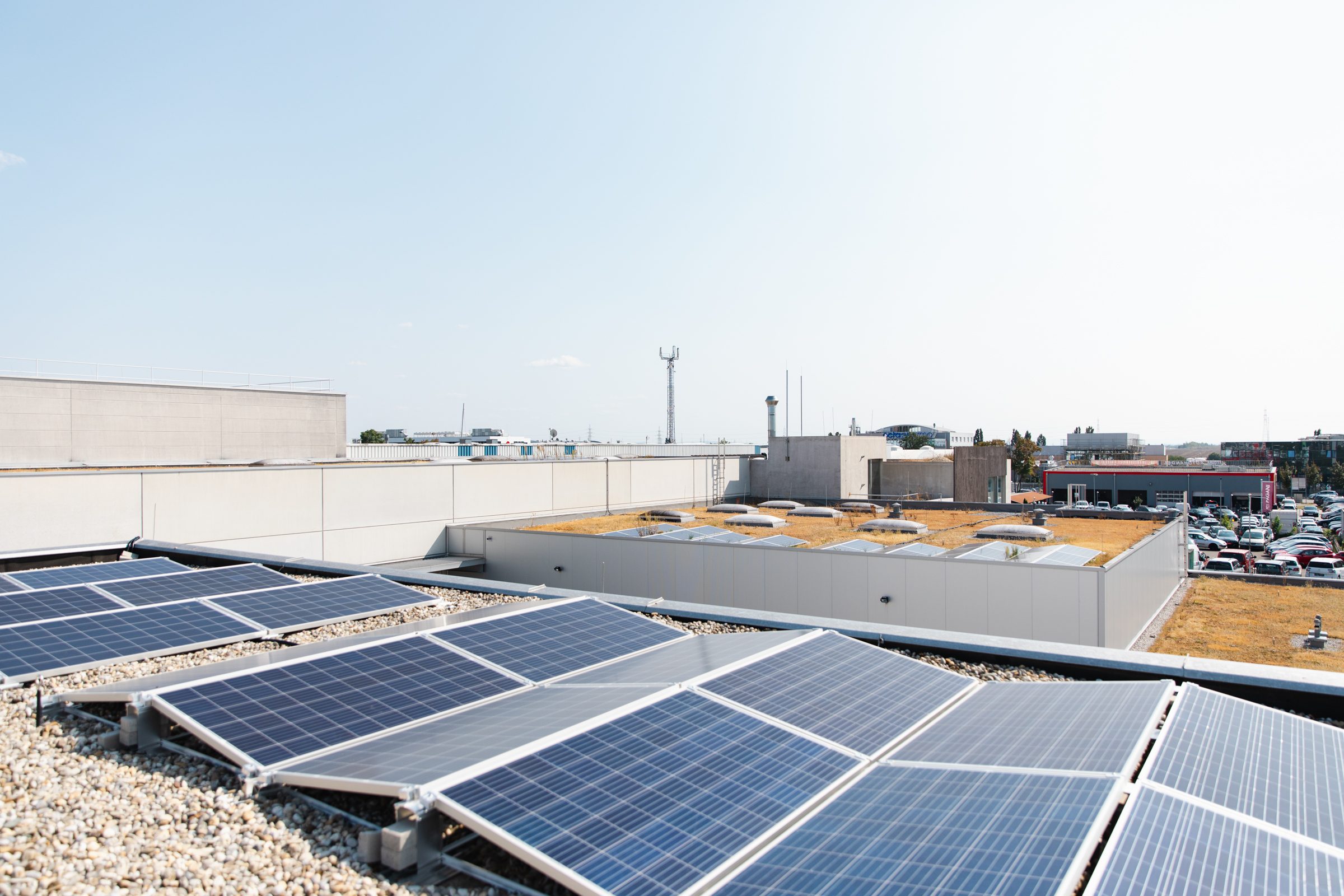 PV-Anlage auf einem Gewerbedach, dahinter weitere Betriebsgebäude